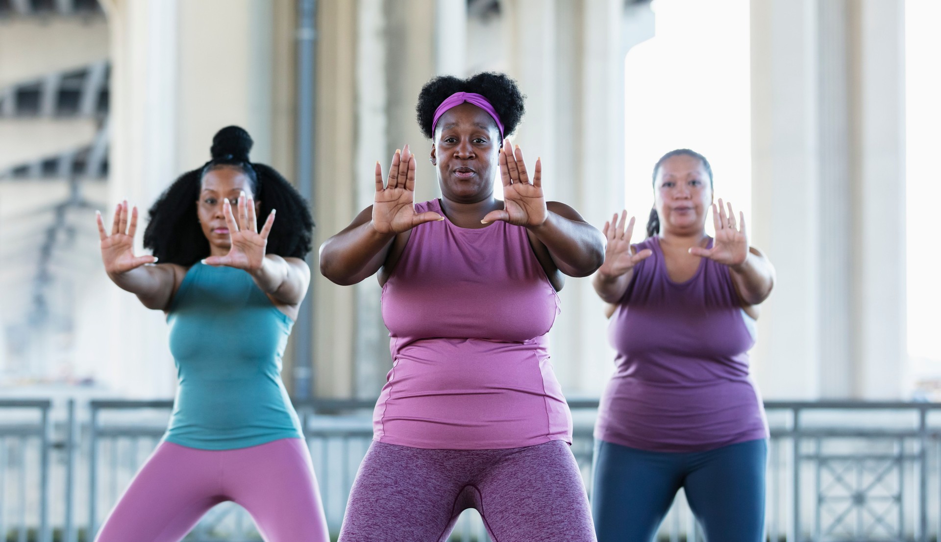 Three multiracial women practicing tai chi in urban area